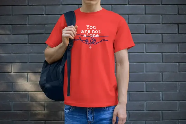 Man wearing a red Blue Eli You Are Not Alone t-shirt