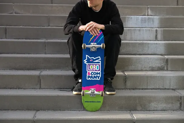 Lobo & Company logo on a skateboard held on concrete steps
