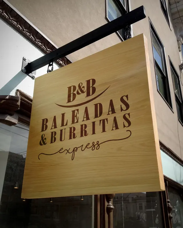 Baleadas & Burritas Express wooden hanging sign on a building