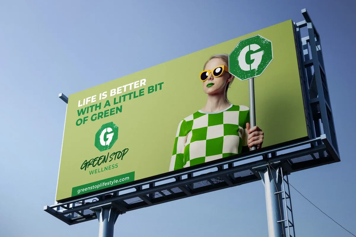 Green Stop Wellness billboard with a woman holding a green stop sign and the line Life is better with a little bit of green