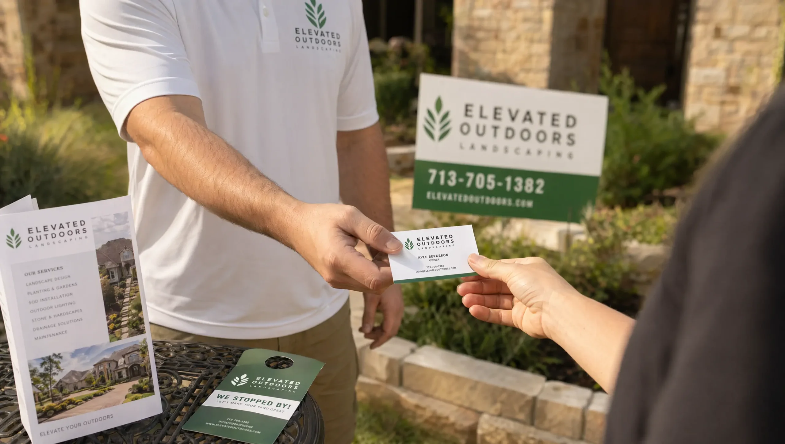Houston landscaping business owner handing a professionally designed business card to a customer with branded flyers and yard signs nearby
